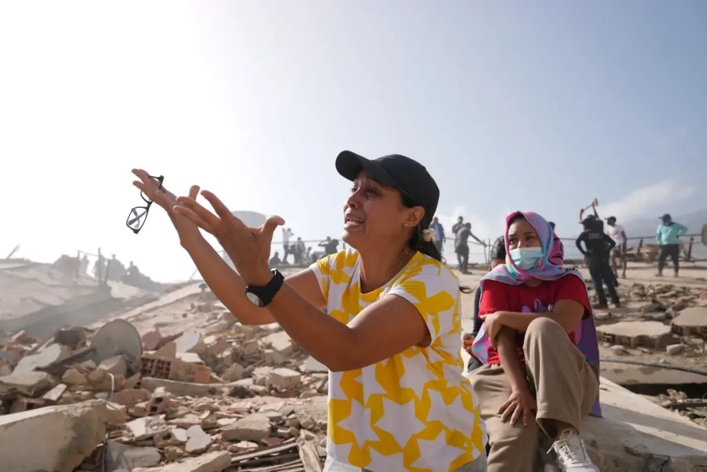 People search for missing relatives at the collapsed building where...