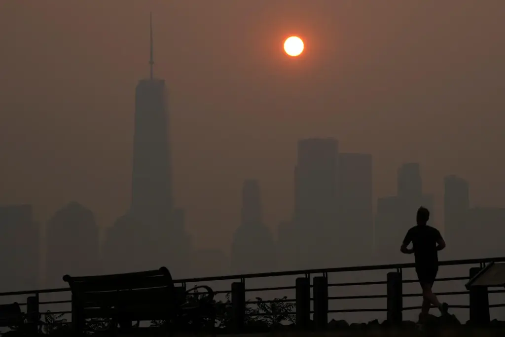 FILE – A man runs in front of the sun...