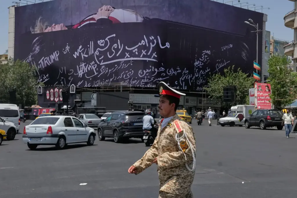 An army cadet walks past a billboard bearing anti-Trump messages.