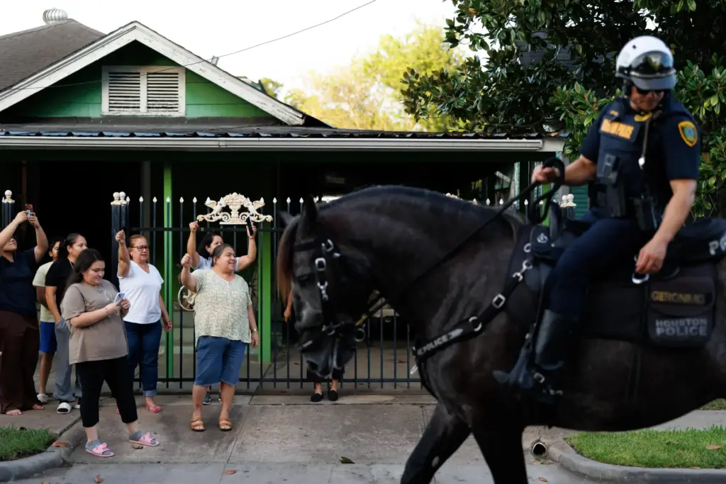 Neighbors cheer as marchers walk past during a vigil for...