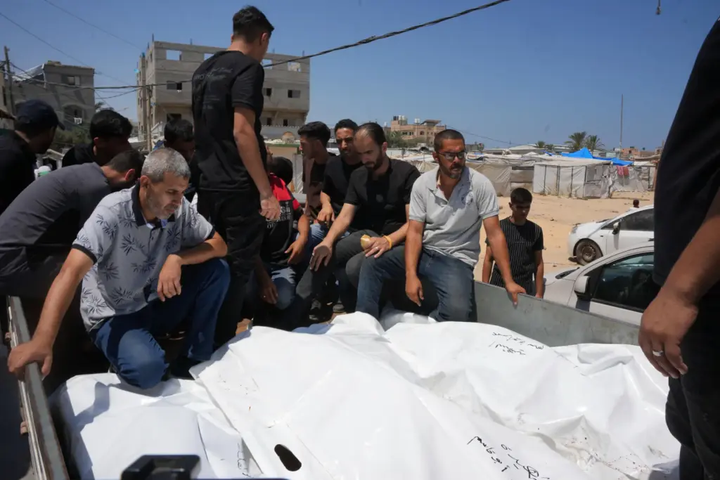 Palestinians carry the bodies of people killed in an Israeli military strike.