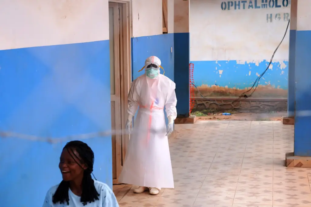 A health worker, wearing protective gear, stands outside the Ebola Treatment Center in Ituri, Congo.