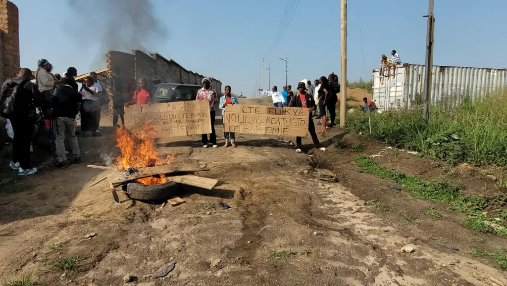 Rubble is set ablaze as health and frontline workers protest at the Elikya Ebola Treatment Center.
