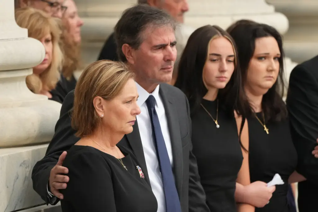 Sen. Darline Graham and her husband, Larry Nordone, watch a team move Lindsey Graham's casket.