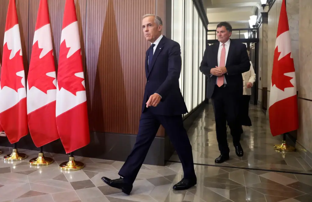 Prime Minister Mark Carney and Canada-U.S. Trade Minister Dominic LeBlanc arrive at a news conference.