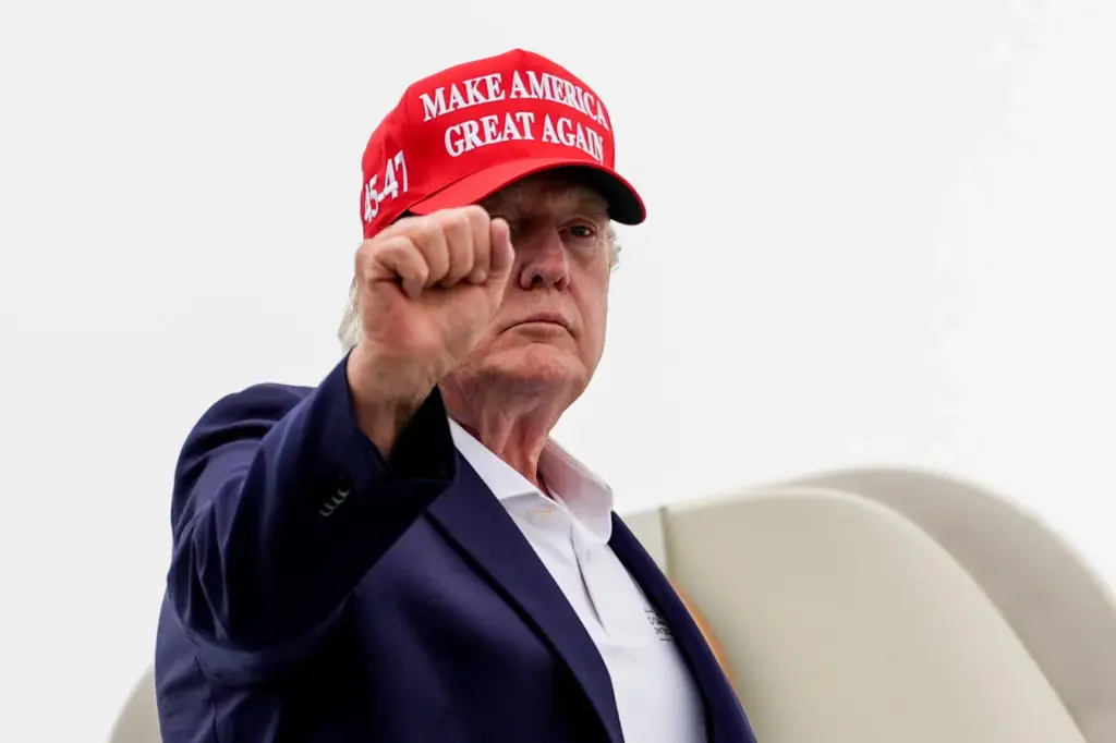 President Donald Trump gestures while boarding Air Force One at...