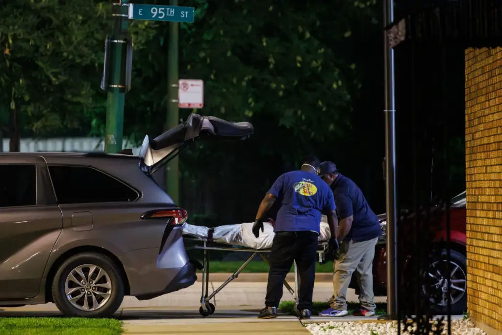 Workers transport a body early Aug. 7, 2026, from the...