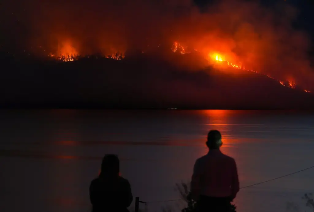 FILE – People in Lake Country, British Columbia, watch as...