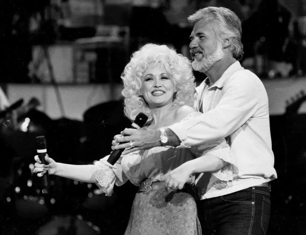 FILE – Dolly Parton, left, and Kenny Rogers rehearse a...