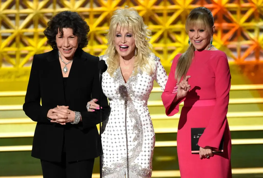 FILE – Dolly Parton, center, stands on stage with Lily...