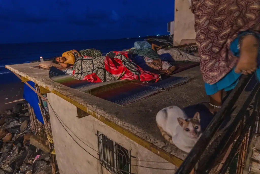 Residents sleep on the roof of their home near Versova Beach to escape the oppressive heat.