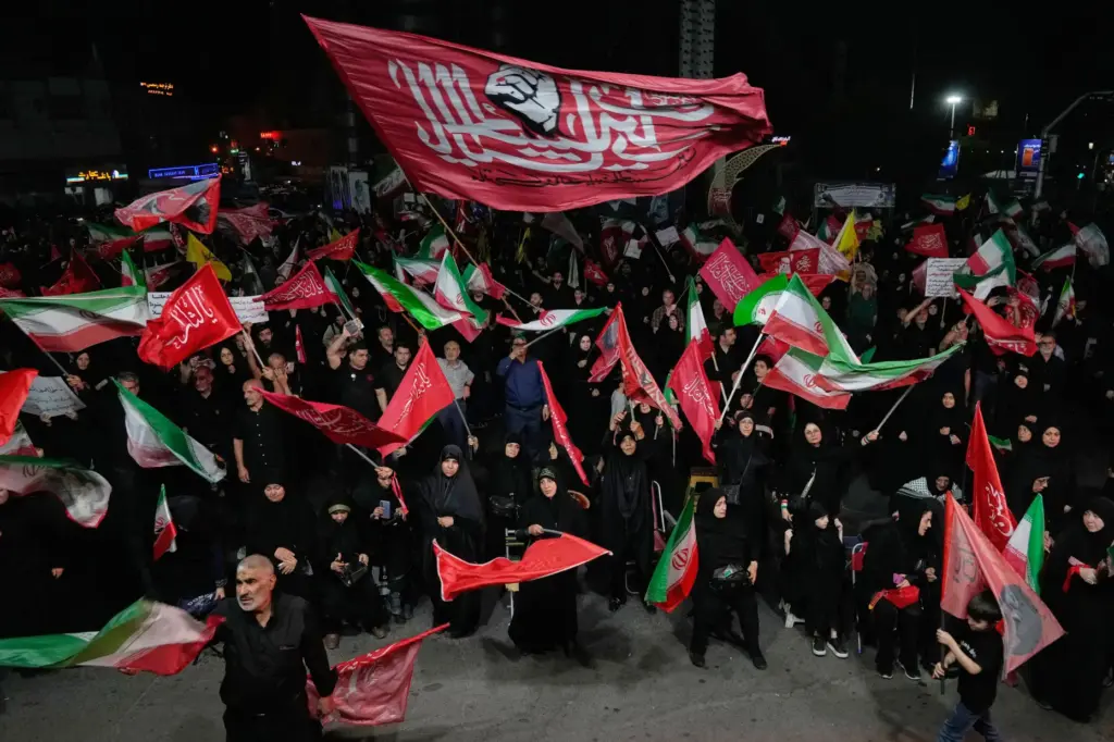 Iranian pro-government demonstrators wave flags in a gathering at a...
