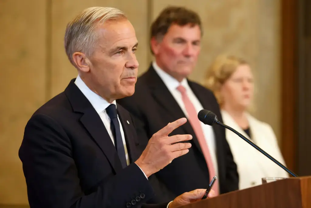Canada-U.S. Trade Minister Dominic LeBlanc and negotiator Janice Charette listen as Prime Minister Mark Carney speaks.