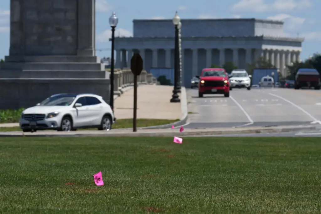 FILE – Flags placed by workers are pictured in the...