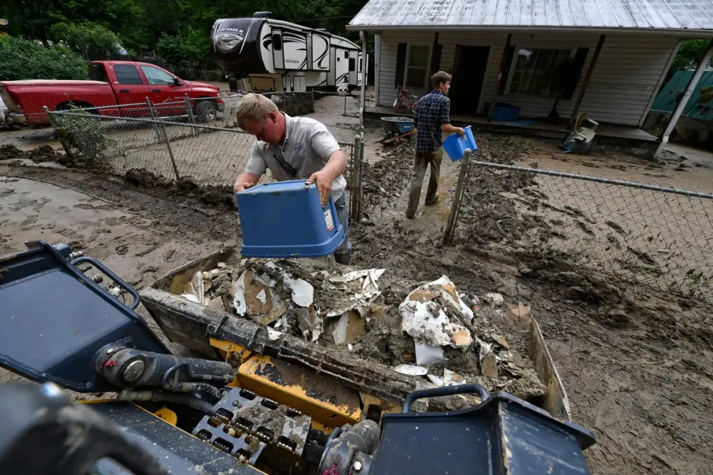 Volunteers from the local mennonite community clean a flood-damaged property from a house.