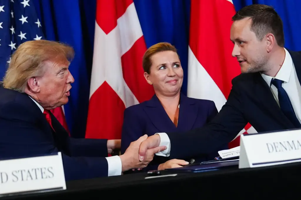 FILE – President Donald Trump, left, shakes hands with Greenland’s...