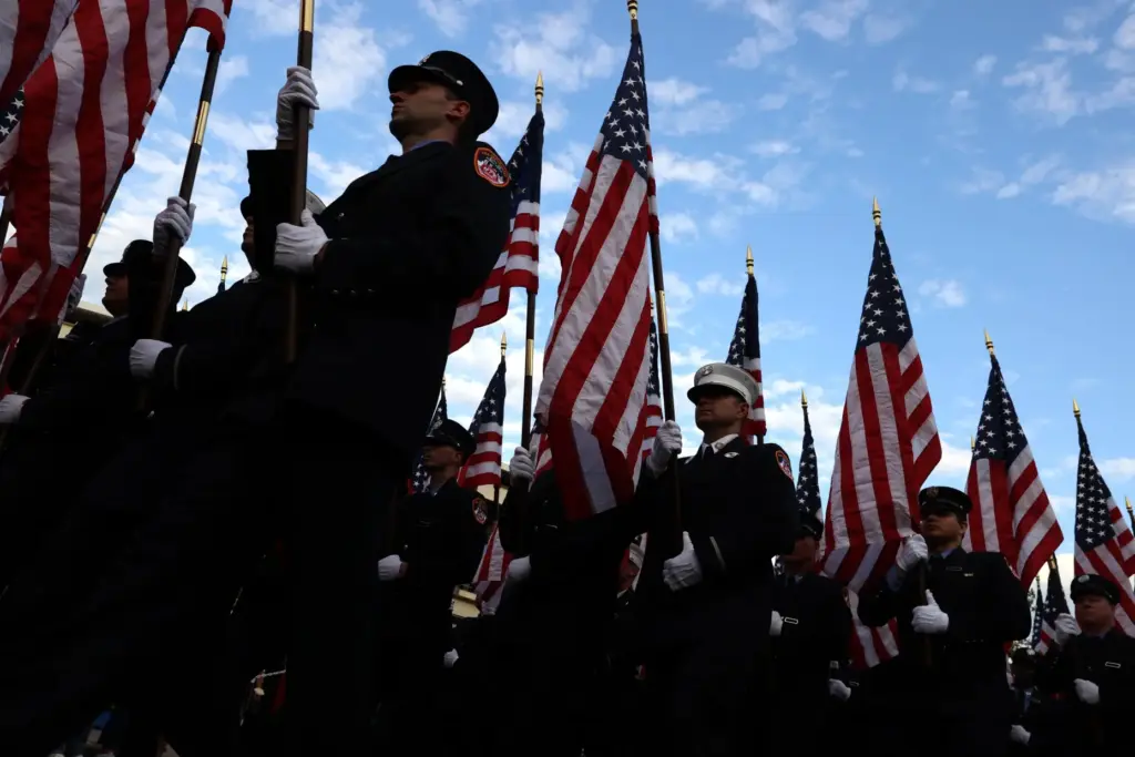 Members of the FDNY march with flags during a 9/11 memorial.