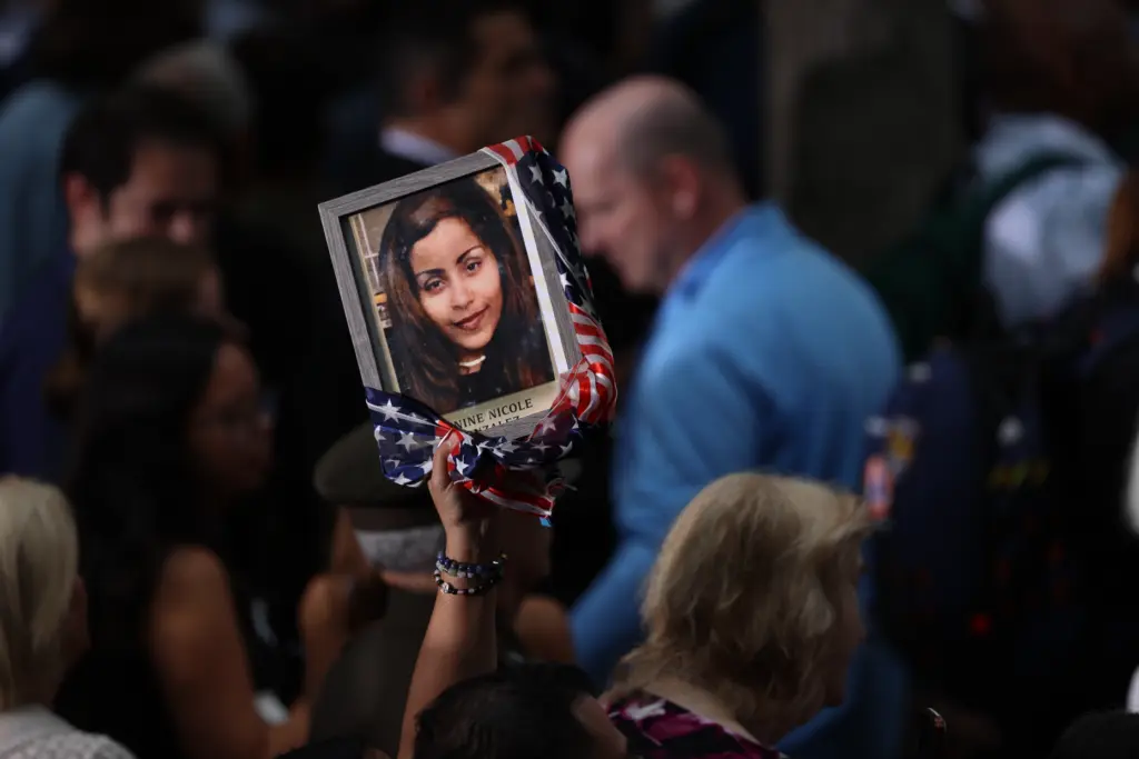 People attend a memorial on the 25th anniversary of the...