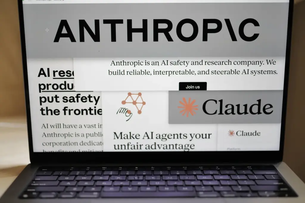 Pages from the Anthropic website and the company's logos are displayed on a computer screen.