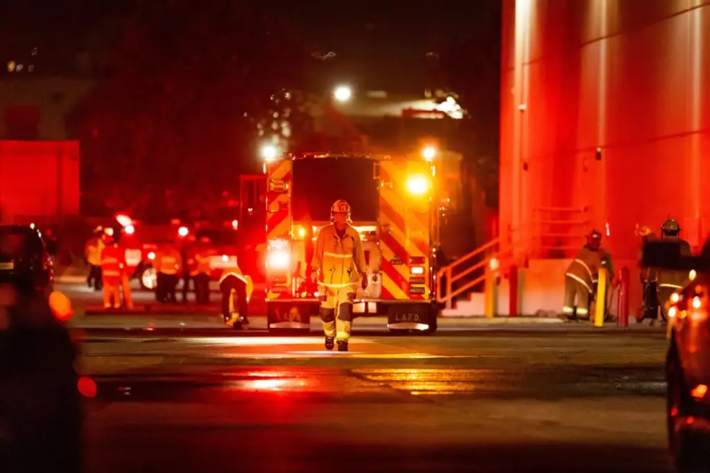First responders work the scene after a helicopter crashed near a bus crash.